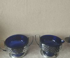 Vintage cobalt blue glass milk jug and sugar bowl with chrome baskets.