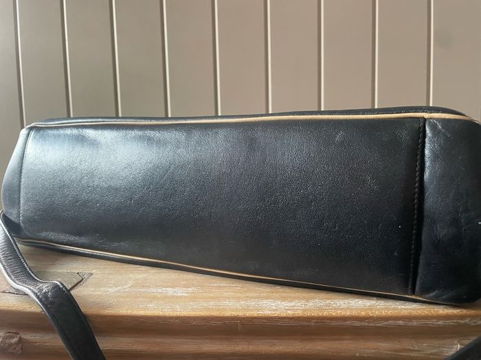 Tula black leather tote bag with a shoulder strap.