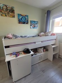 Mid-sleeper bed with pullout desk and underbed cabinet unit.