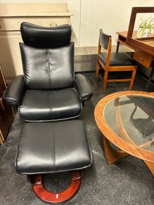 Pair of leather style armchairs with matching footstools