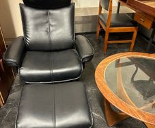 Pair of leather style armchairs with matching footstools