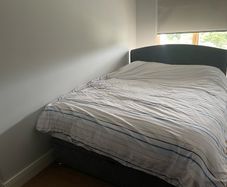 Upholstered grey double bed base with storage and headboard