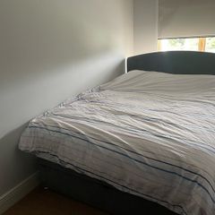 Upholstered grey double bed base with storage and headboard