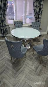 White round glass table with four chairs