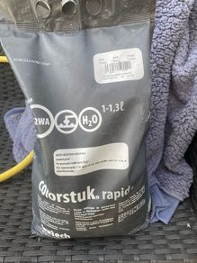 Bag of grey grout and some wall tiles