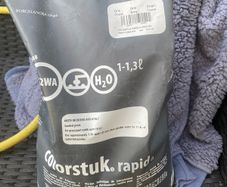 Bag of grey grout and some wall tiles