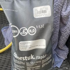 Bag of grey grout and some wall tiles