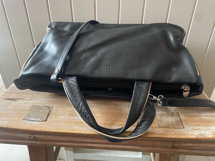 Tula black leather tote bag with a shoulder strap.