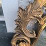 large, ornate gold mirror features a baroque frame Image 5