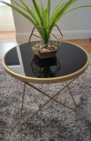 Round side table with black glass top and gold frame