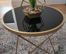 Round side table with black glass top and gold frame