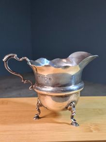 Antique silver cream jug with scalloped rim
