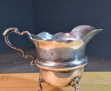 Antique silver cream jug with scalloped rim