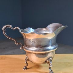 Antique silver cream jug with scalloped rim
