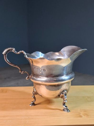 Antique silver cream jug with scalloped rim