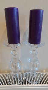 2 large glass candle sticks with candles