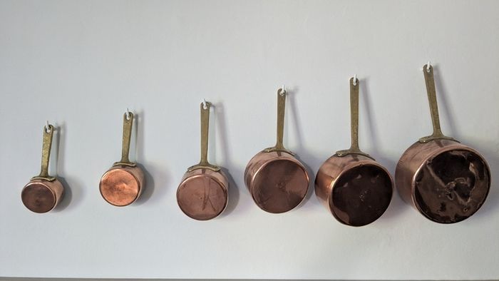 Set of 6 graduated copper saucepans with brass handles
