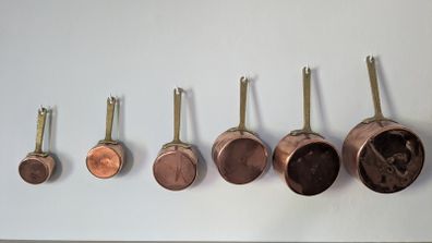 Set of 6 graduated copper saucepans with brass handles