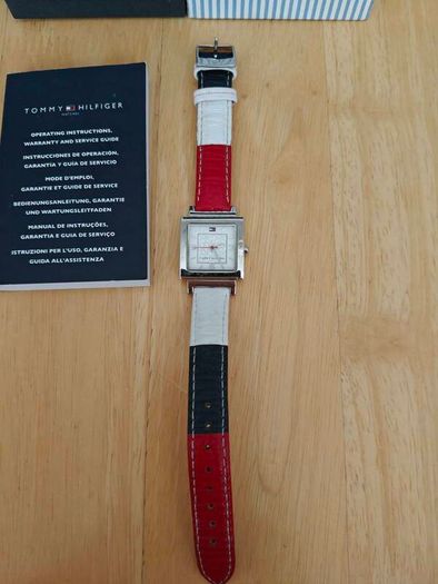 Tommy Hilfiger watch features a distinctive rectangular stainless steel case and a reversible red, white, and blue leather strap