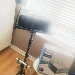 philips neopix ultra 2tv+ home projector and height adjustable stand, built in speakers and android TV with play store stand comes with power point bracket on it as seen in pictures also remote and phone holder