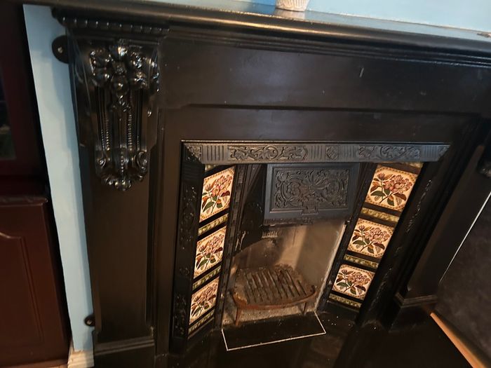 Victorian style cast iron fireplace with floral tiles