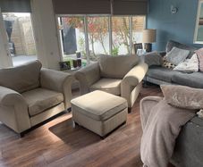 Two extra wide beige armchairs and pouffe