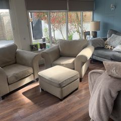 Two extra wide beige armchairs and pouffe