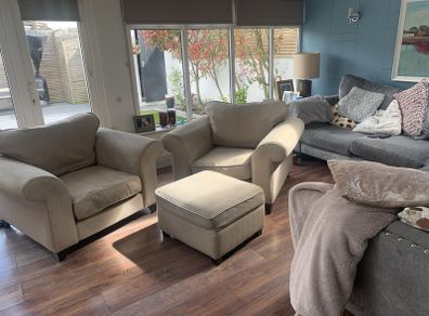 Two extra wide beige armchairs and pouffe