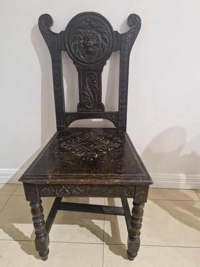 Carved oak antique chair with lion face motif