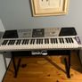 RockJam Electronic Keyboard Piano set up on a sturdy, matching heavy-duty Z-frame stand and an adjustable padded X-frame RockJam Keyboard Bench resting on a wooden surface. Image 2