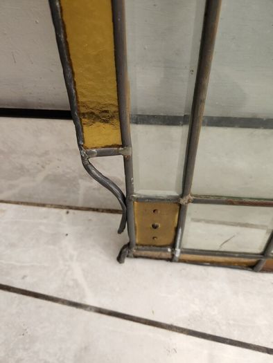 Vintage leaded glass with curved brass screen .