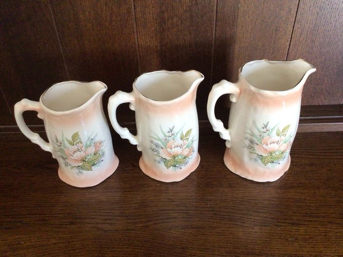 A set of 3 Large Peach Floral porcelain Graduating jugs