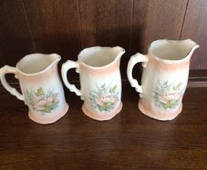 A set of 3 Large Peach Floral porcelain Graduating jugs