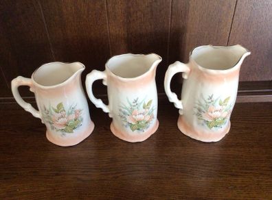 A set of 3 Large Peach Floral porcelain Graduating jugs