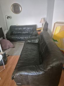 Two black leather three seater couch