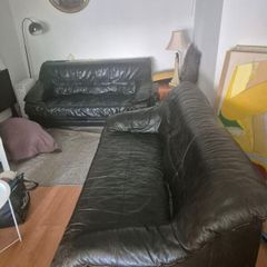 Two black leather three seater couch