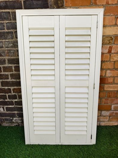 Vintage-style louvered white internal window shutter