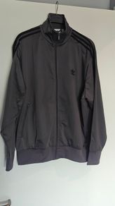 Adidas Firebird tracksuit top. Nice grey color. Black three stripes. New. Never worn.