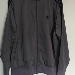 Adidas Firebird tracksuit top. Nice grey color. Black three stripes. New. Never worn.