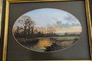 VINTAGE Framed landscape print featuring an oval matte aperture with a golden sunset or sunrise over a river, bare trees, and two birds flying in the sky.