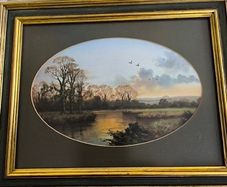 VINTAGE Framed landscape print featuring an oval matte aperture with a golden sunset or sunrise over a river, bare trees, and two birds flying in the sky.