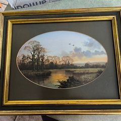 VINTAGE Framed landscape print featuring an oval matte aperture with a golden sunset or sunrise over a river, bare trees, and two birds flying in the sky.