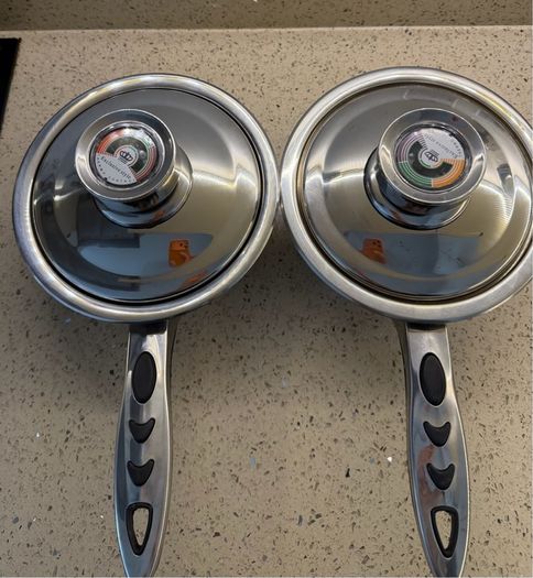 stainless steel saucepans featuring "Thermo Control" knobs on the lids