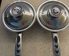 stainless steel saucepans featuring "Thermo Control" knobs on the lids