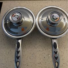 stainless steel saucepans featuring "Thermo Control" knobs on the lids