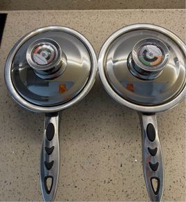 stainless steel saucepans featuring "Thermo Control" knobs on the lids