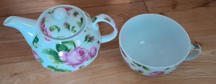 Tea for one: tea pot and cup with rose design on white