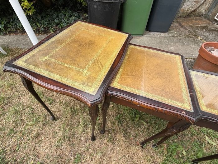 A vintage glass-protected, gold-tooled, leather top nest of tables