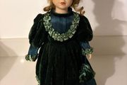 Vintage porcelain doll in green velvet dress