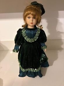 Vintage porcelain doll in green velvet dress